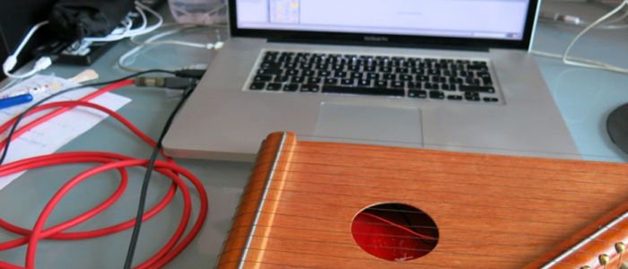 citara conectada a una interfaz de audio y un ordenador mac book pro